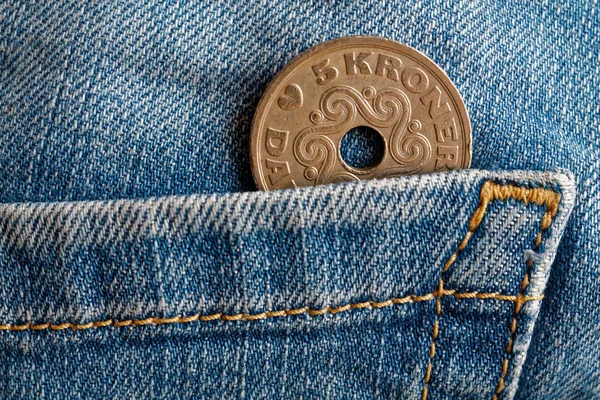 Denmark coin denomination is 5 krone (crown) in the pocket of old blue worn denim jeans
