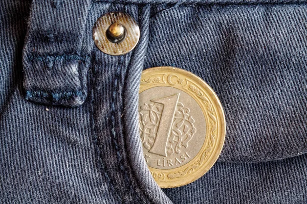 Turkish coin with a denomination of one lira in the pocket of obsolete blue denim jeans