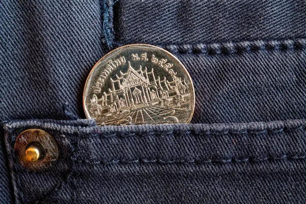 Moneta thailandese con un taglio di 5 baht nella tasca di jeans in denim grigio — Foto Stock