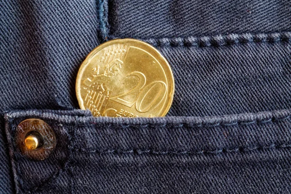 Moneta in euro con un taglio di venti centesimi di euro nella tasca di jeans in denim blu scuro — Foto Stock