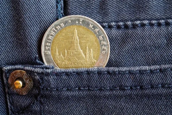 Moneda tailandesa con una denominación de 10 baht en el bolsillo de vaqueros grises — Foto de Stock