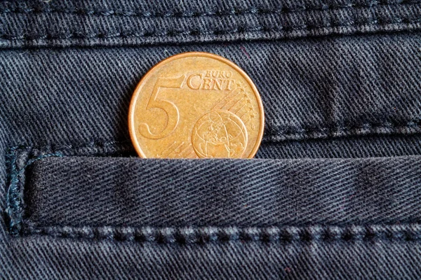 Euro-érme megfelelő címletű 5 euro cent a zsebében, a kopott, szürke farmer — Stock Fotó