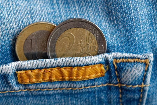 Дві монети євро з Деномінація один і два євро в кишені носити синіх джинсів — стокове фото