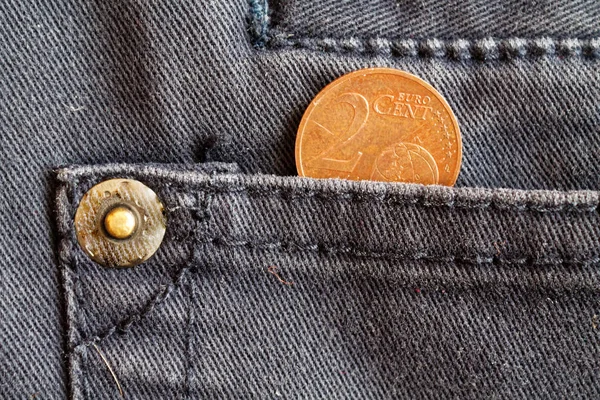 Moneta in euro con un taglio di due centesimi di euro nella tasca di jeans in denim blu scuro — Foto Stock