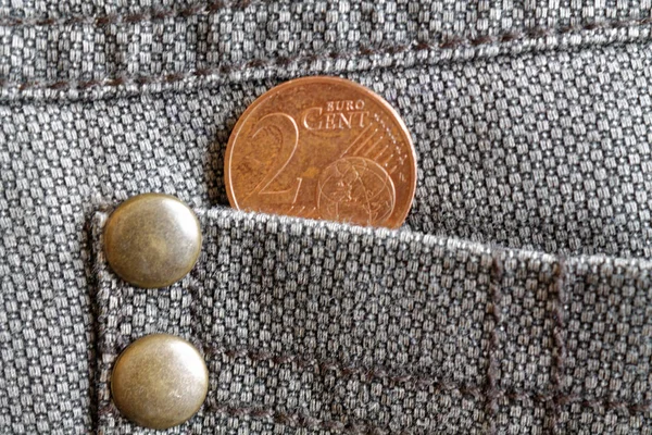 欧元硬币的面额2欧元的旧破旧的棕色牛仔牛仔裤口袋里 — 图库照片