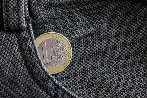 Moneta Euro con un taglio di un euro nella tasca dei jeans in denim grigio indossati — Foto Stock