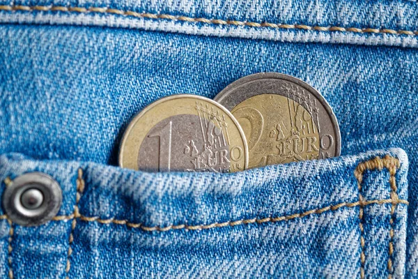 Дві монети євро з Деномінація 1 і 2 євро в кишені носити старі синіх джинсів — стокове фото
