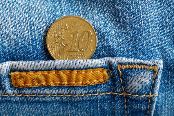 Euromynt med ett nominellt värde av tio eurocent i fickan på slitna blå denim jeans med orange skosnören — Stockfoto