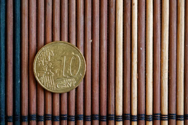 Ψέμα κέρμα ενός ευρώ στο τραπέζι ξύλινο μπαμπού ονομαστική αξία είναι 10 ευρώ εκατό — Φωτογραφία Αρχείου