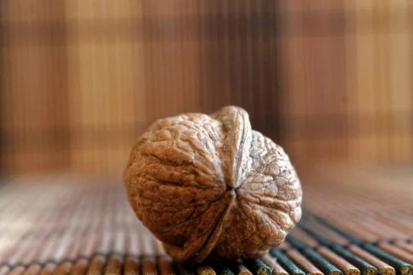 Орех лежать на деревянном бамбуковом столе, фон для веб-сайта или мобильных устройств . — стоковое фото