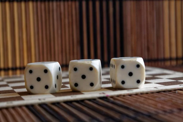 Pilha de três dados de plástico branco sobre fundo placa de madeira marrom. Cubo de seis lados com pontos pretos. Número 5 — Fotografia de Stock