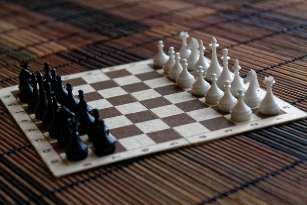 Placa de xadrez de madeira e peças de xadrez de plástico, a bordo — Fotografia de Stock