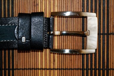 Siyah kuşak ahşap masa üzerinde parlak toka ile