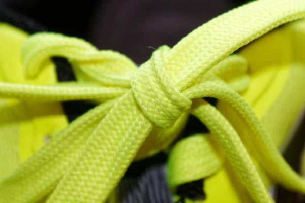 Concepto deportivo, primer plano del zapato, concepto de bienestar, encaje amarillo en zapatillas azules de cerca. Detalle de zapato amarillo en zapatillas de running . —  Fotos de Stock