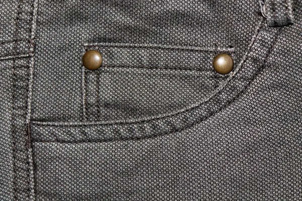 Detailed closeup of blank grungy denim. Vintage gray jeans with rivet, good for background — Stock Photo, Image