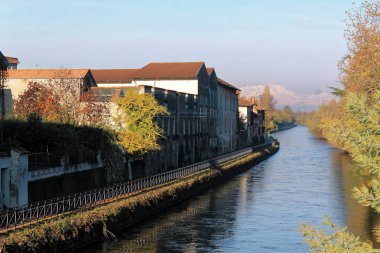 Su kanalı (kanal) ve ağaçlar ve binalar Robbecoo sul Naviglio, İtalya için yansımaları