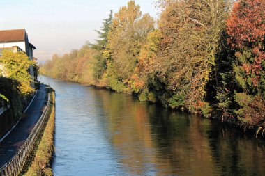 Su kanalı (kanal) ve ağaçlar ve binalar Robbecoo sul Naviglio, İtalya için yansımaları