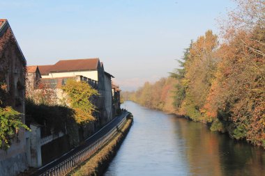 Su kanalı (kanal) ve ağaçlar ve binalar Robbecoo sul Naviglio, İtalya için yansımaları