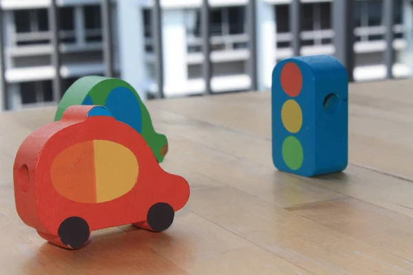Houten speelgoedauto 's met verkeerslicht op tafel. — Stockfoto