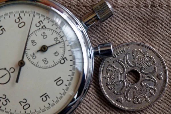 Moneda de Dinamarca con una denominación de cinco corona (corona) (reverso) y cronómetro sobre fondo denim beige desgastado - fondo empresarial —  Fotos de Stock