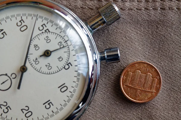 Moneta in euro con un taglio di un centesimo di euro (lato posteriore) e cronometro sul vecchio sfondo di jeans beige - sfondo aziendale — Foto Stock