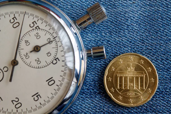 Moneta in euro con un taglio di venti centesimi di euro (lato posteriore) e cronometro su sfondo denim blu consumato - sfondo aziendale — Foto Stock