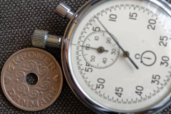 Denemarken muntstuk met een nominale waarde van 5 kroon (kroon) en stopwatch op versleten bruin denim achtergrond - zakelijke achtergrond — Stockfoto