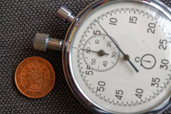 Pièce en euros avec une valeur unitaire de deux centimes d'euro (face arrière) et chronomètre sur fond de denim brun - arrière-plan de l'entreprise — Photo