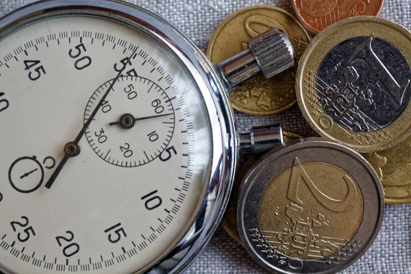 Keten zemin üzerine eski vintage kronometre ile euro sikke yığını — Stok fotoğraf