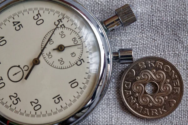 Denemarken muntstuk met een nominale waarde van 2 kroon (kroon) en stopwatch op linnen doek achtergrond - zakelijke achtergrond — Stockfoto