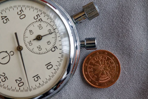 Pièce en euros avec une valeur unitaire de deux centimes d'euro (face arrière) et chronomètre sur fond de denim gris - arrière-plan d'affaires — Photo