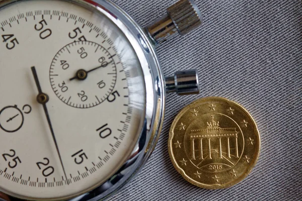 Pièce en euros avec une valeur unitaire de vingt centimes d'euro (face arrière) et chronomètre sur fond de denim gris - fond d'affaires — Photo