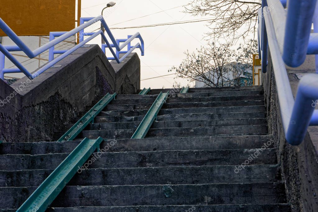 Cement grunge stone stairs with blue handicapped rails