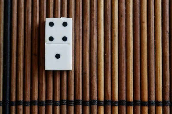 Kawałek Domino na bambusowym drewnianym stole tła. Zestaw Domino-jeden-4 kropki. — Zdjęcie stockowe