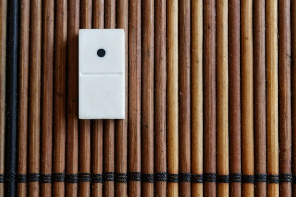 Kawałek Domino na bambusowym drewnianym stole tła. Domino zestaw pusty-jedna kropka. — Zdjęcie stockowe