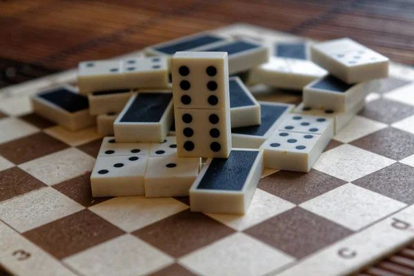 Montón caótico de piezas de dominó sobre el fondo de mesa de madera marrón bambú —  Fotos de Stock