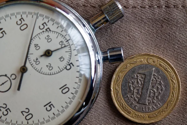 Moneda turca con denominación de 1 lira y cronómetro sobre fondo denim beige desgastado - fondo empresarial —  Fotos de Stock