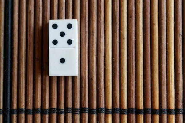 Kawałku Domino na tle brązowy drewniany stół bambusa. Domino zestaw - 1-5 punktów. — Zdjęcie stockowe