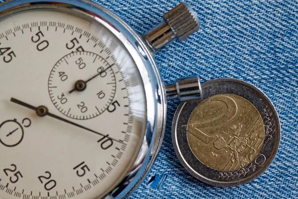 2 ユーロとブルーデニムの背景 - ビジネスの背景にストップウォッチの名称とユーロ硬貨 — ストック写真
