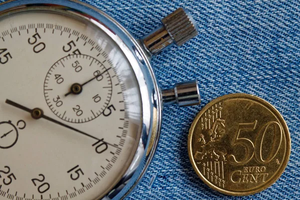 Pièce en euros avec une valeur nominale de 50 centimes d'euros et chronomètre sur fond de denim bleu - arrière-plan d'affaires — Photo