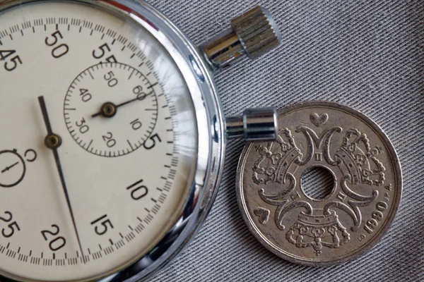 Denmark coin with a denomination of five crown (krone) (back side) and stopwatch on gray denim backdrop - business background — Stock Photo, Image