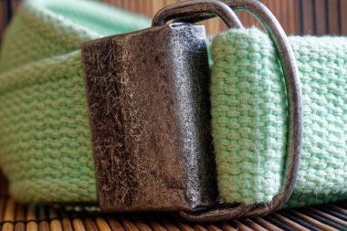 Ahşap arka plan üzerinde izole Moda yeşil Kemer toplu.