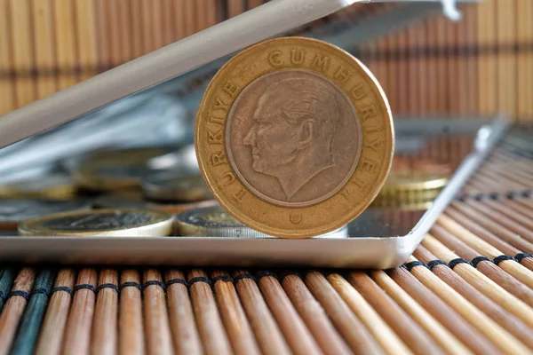 Σωρός από Τουρκικά κέρματα ονομαστικής αξίας μία λίρα σε καθρέφτη αντανακλούν πορτοφόλι ψέματα σε ξύλινα μπαμπού πίνακα φόντο - πίσω όψη — Φωτογραφία Αρχείου