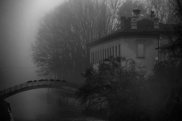 Antiguo puente de piedra de arco en el tiempo brumoso, neblina invierno en Italia — Foto de Stock