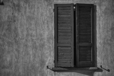 Güneşli bir günde açık vintage pencere kepenk, İtalya tarzı beton çimento duvar