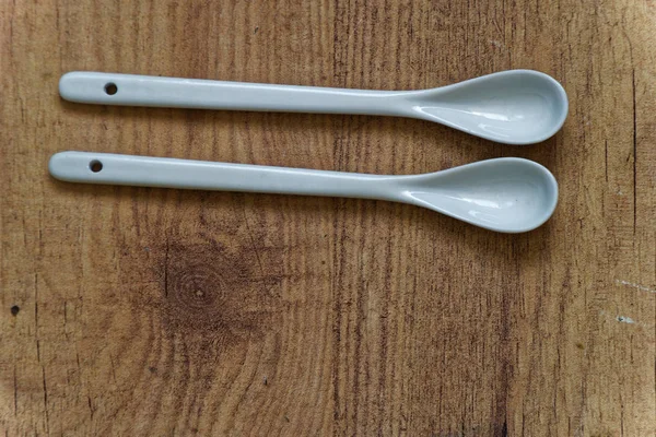 Λευκό κεραμικό κουτάλι στο ξύλινο τραπέζι, το top view, κουζίνα φόντο — Φωτογραφία Αρχείου