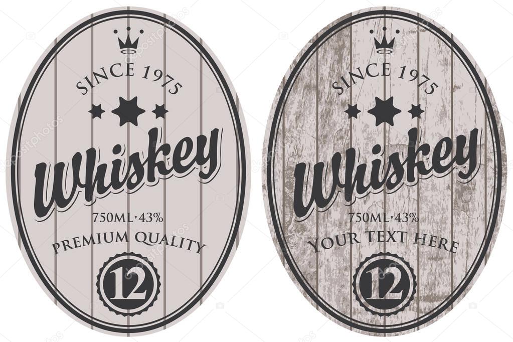 two oval labels for whiskey on wooden background
