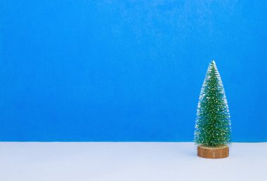 Açık mavi arkaplanda yeşil Noel ağacı