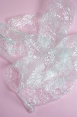 Pembe arka planda bir sürü boş plastik torba var.