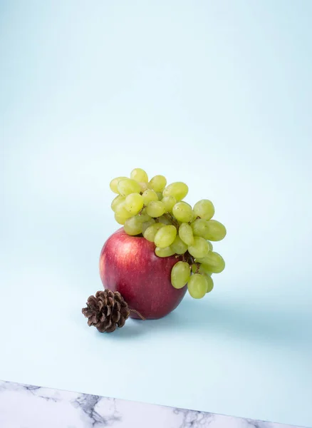 Tak Druif Ligt Grote Rode Appel Met Dennenappel Blauwe Achtergrond — Stockfoto